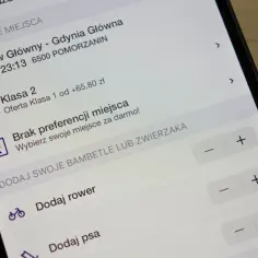 Ekran telefonu z aplikacją do rezerwacji miejsc w pociągu, pokazujący dostępne opcje.