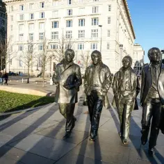 Pomnik Beatlesów na tle budynków w mieście beatlesów.