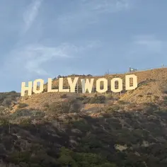 Słynny napis HOLLYWOOD, symbol marzeń i kina, gdzie jest? Wzgórze w słoneczny dzień, z antenami na szczycie.