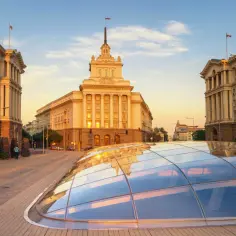 Gdzie jest Sofia? Na placu przed monumentalnym budynkiem, w blasku zachodzącego słońca, odbijającym się w szklanej kopule.