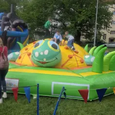 Dzieci bawią się na dmuchanej gąsienicy, jednej z wielu atrakcji na dzień dziecka.