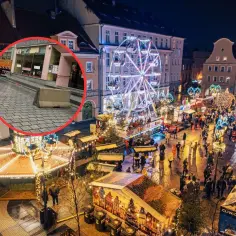 Gliwice jarmark bożonarodzeniowy nocą. Wesołe miasteczko, stragany, tłumy ludzi i betonowa bariera bezpieczeństwa.