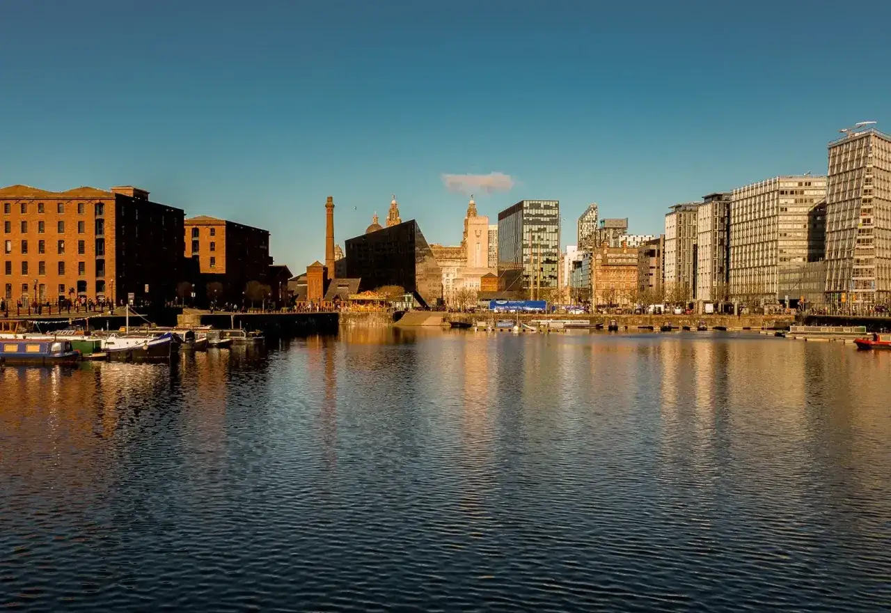 Widok na nowoczesną i historyczną architekturę Liverpoolu nad wodą.