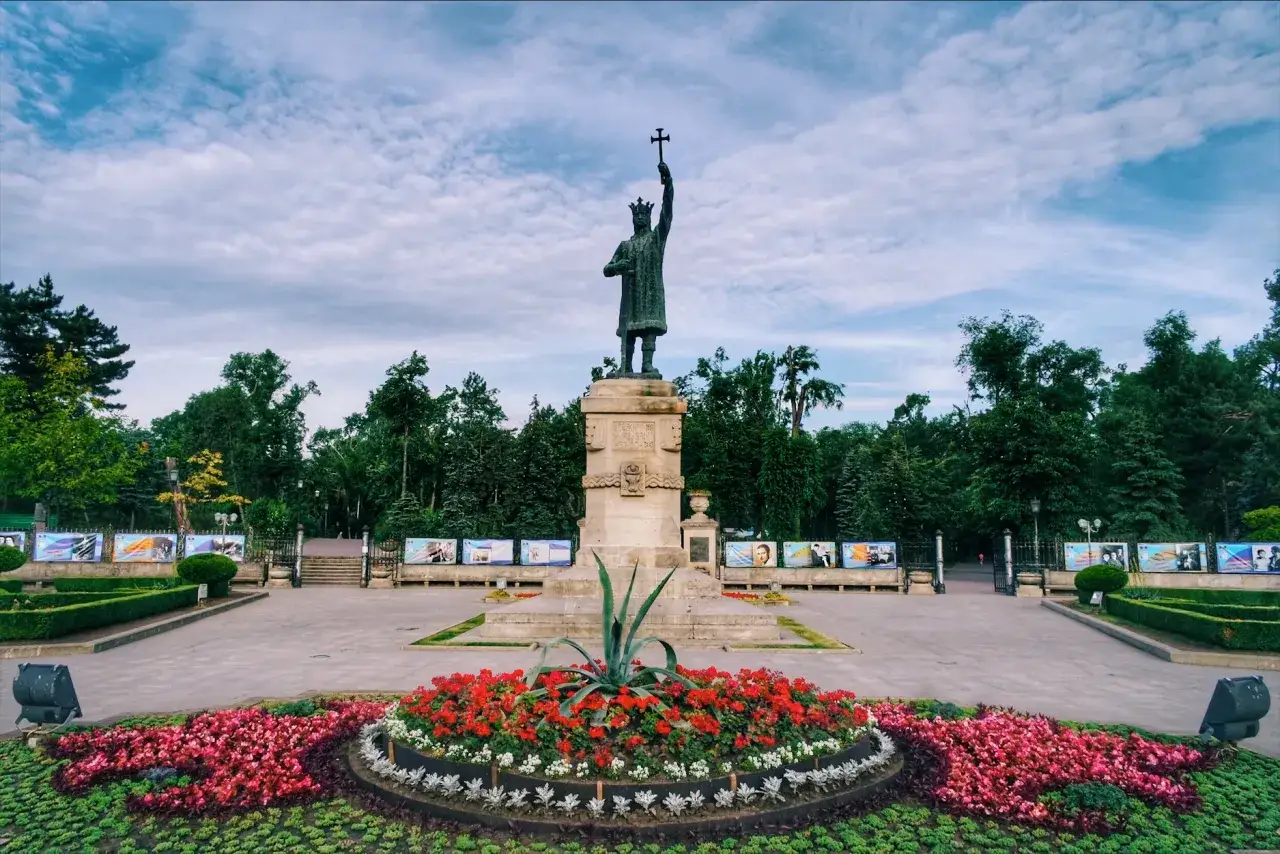Pomnik Stefana Wielkiego, symbol Kiszyniowa, stolicy Mołdawii, otoczony kwitnącymi rabatami i zielenią.