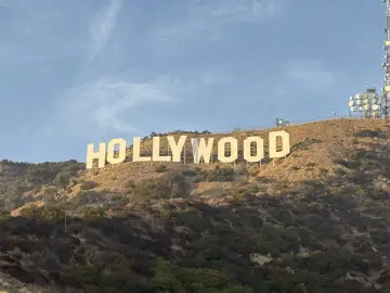Słynny napis HOLLYWOOD, symbol marzeń i kina, gdzie jest? Wzgórze w słoneczny dzień, z antenami na szczycie.