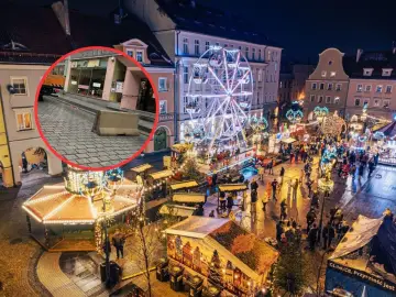 Gliwice jarmark bożonarodzeniowy nocą. Wesołe miasteczko, stragany, tłumy ludzi i betonowa bariera bezpieczeństwa.